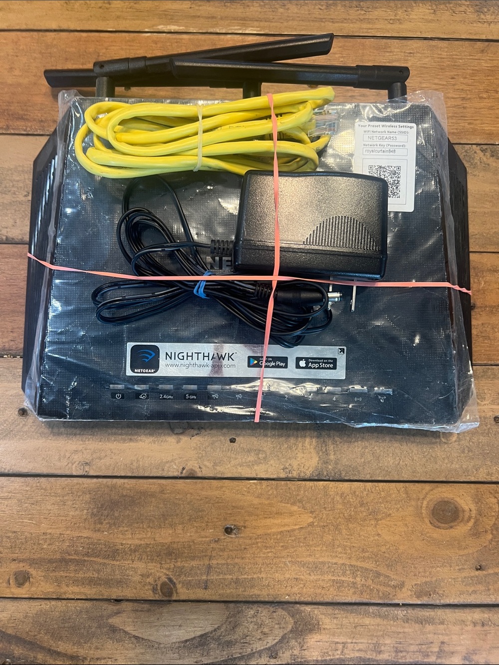 NETGEAR Nighthawk Router with Yellow Ethernet Cable and Black Power Adapter